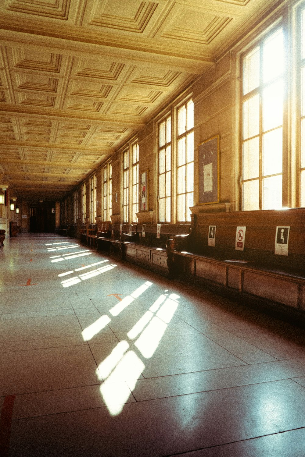 a long hallway with lots of windows and benches