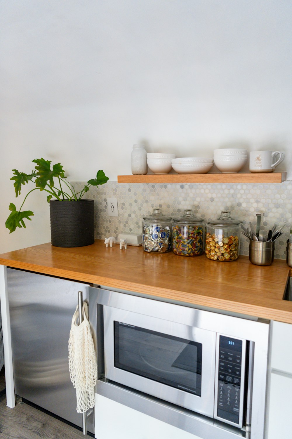 a kitchen counter with a microwave and a potted plant