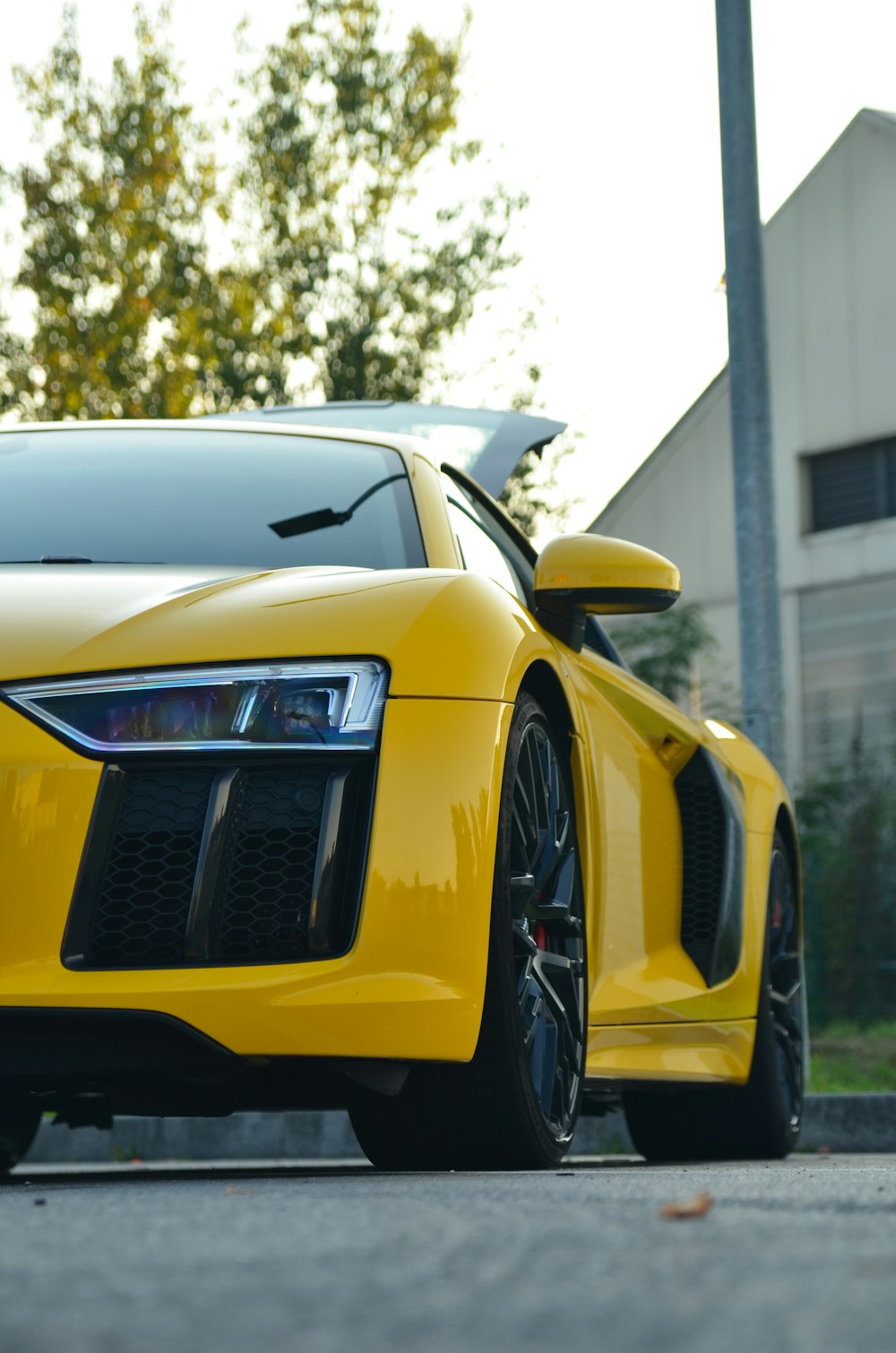 a yellow sports car parked on the side of the road