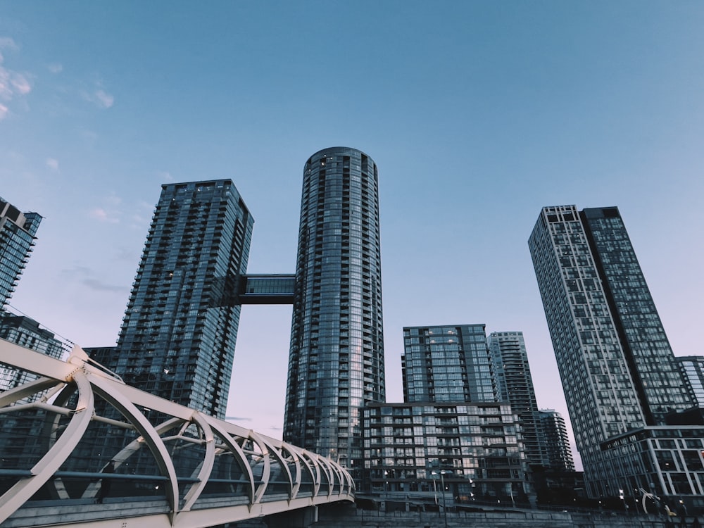 a bridge over a body of water with tall buildings in the background