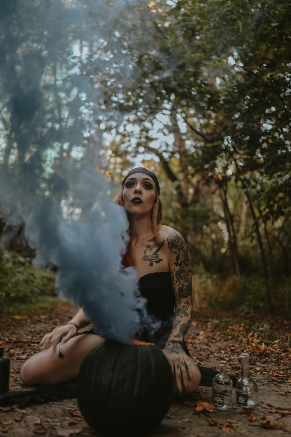 a woman sitting on the ground with smoke coming out of her mouth