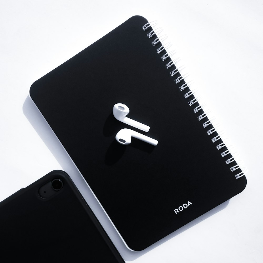 a notebook with a pair of ear buds attached to it