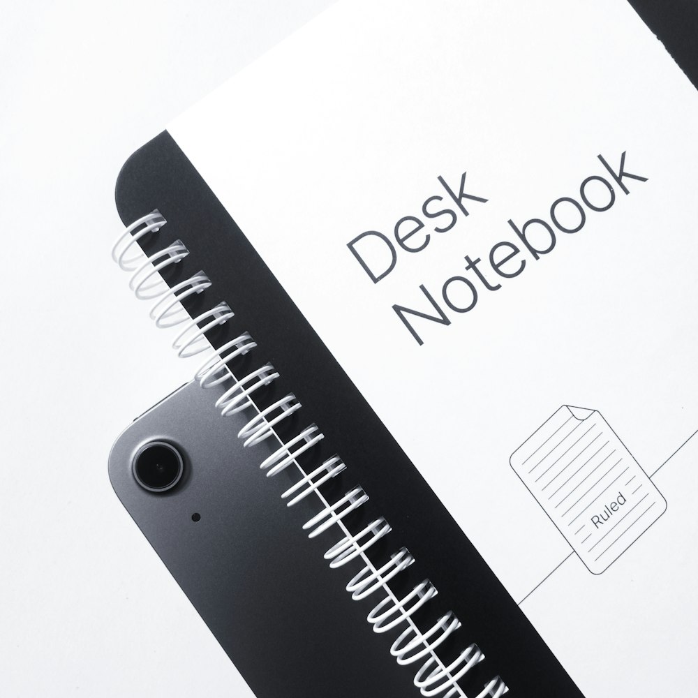 a black and white photo of a desk notebook