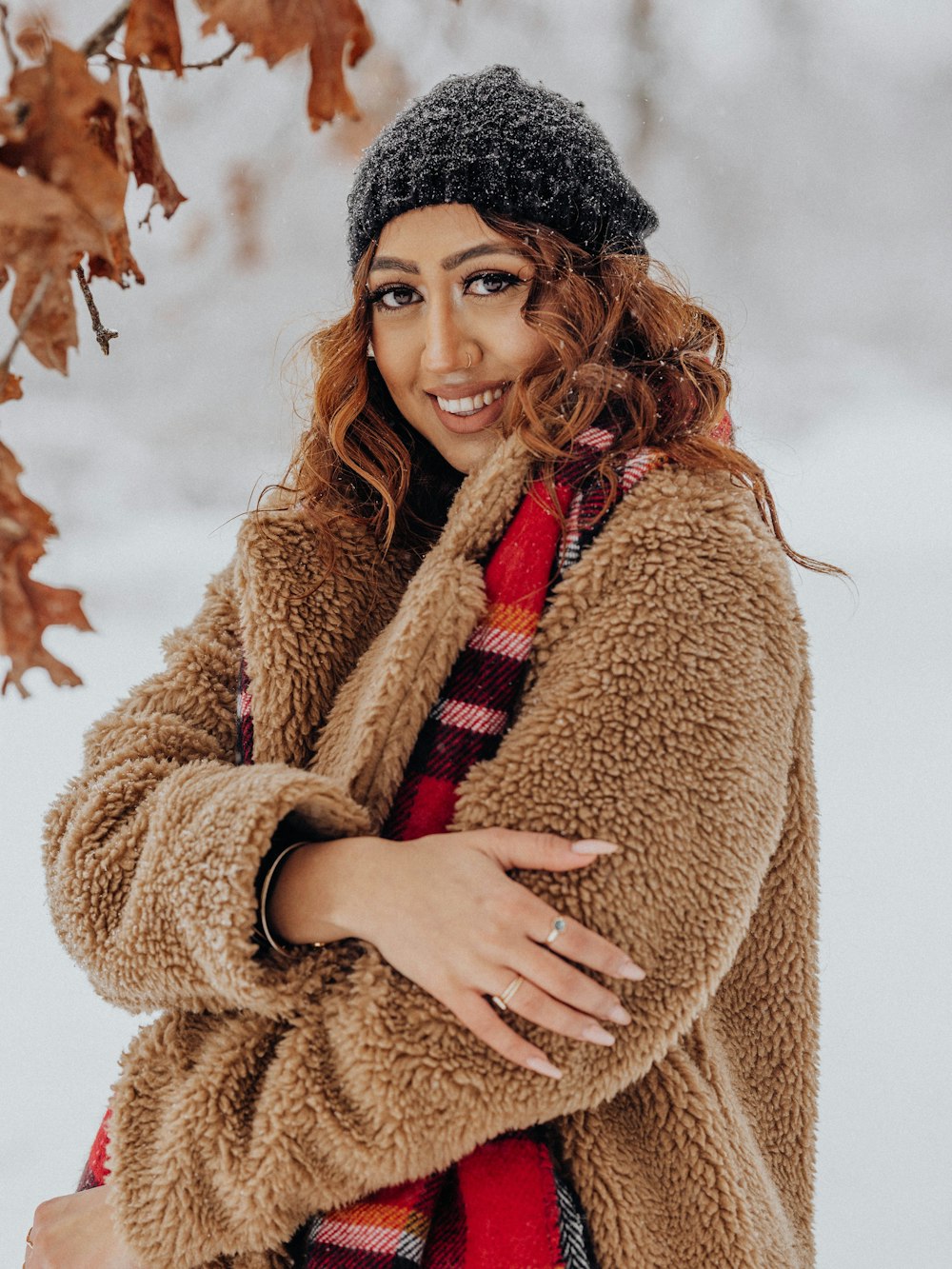 a woman standing in the snow with her arms crossed