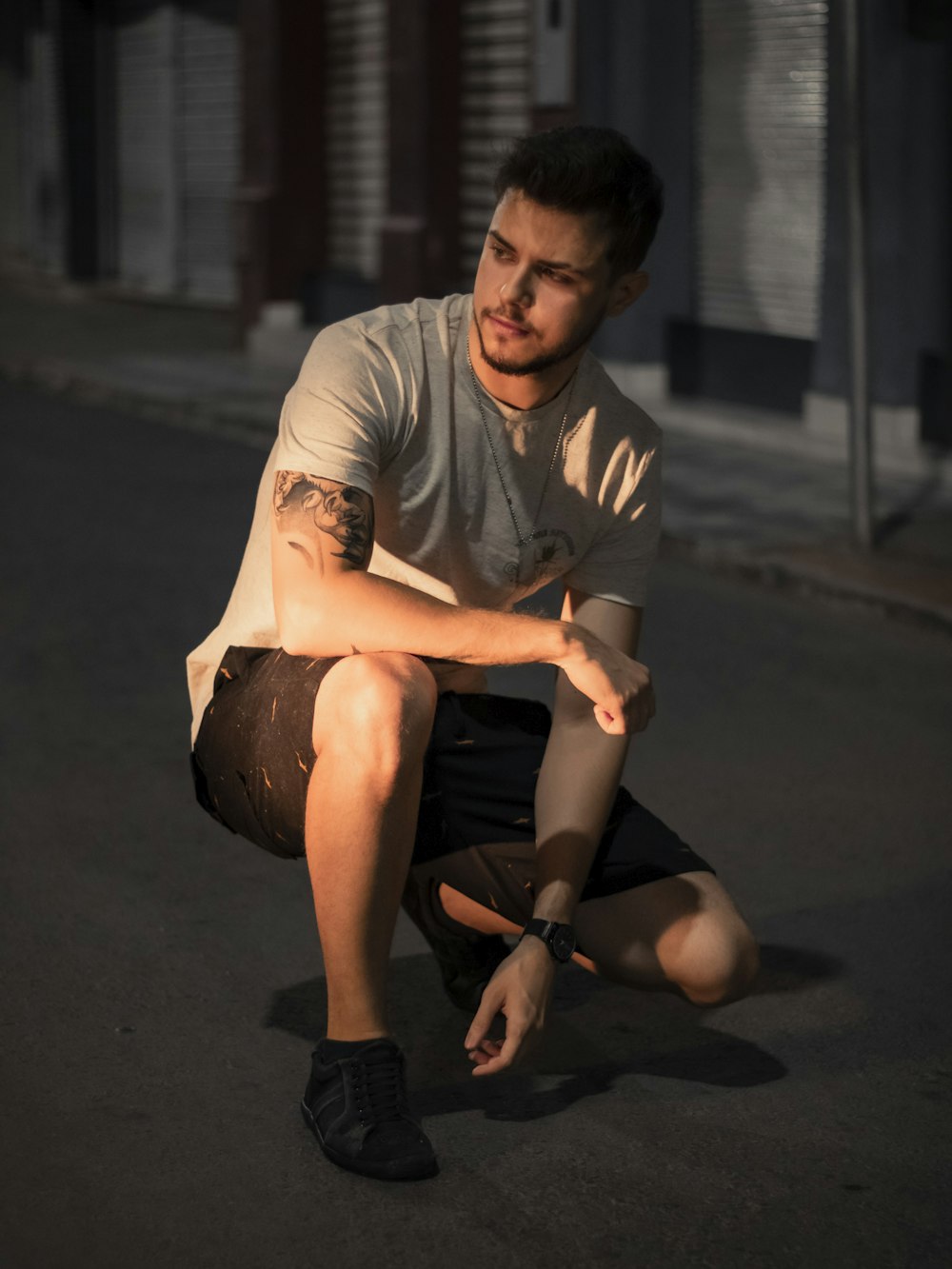 a man kneeling down on the ground with his hand on his knee