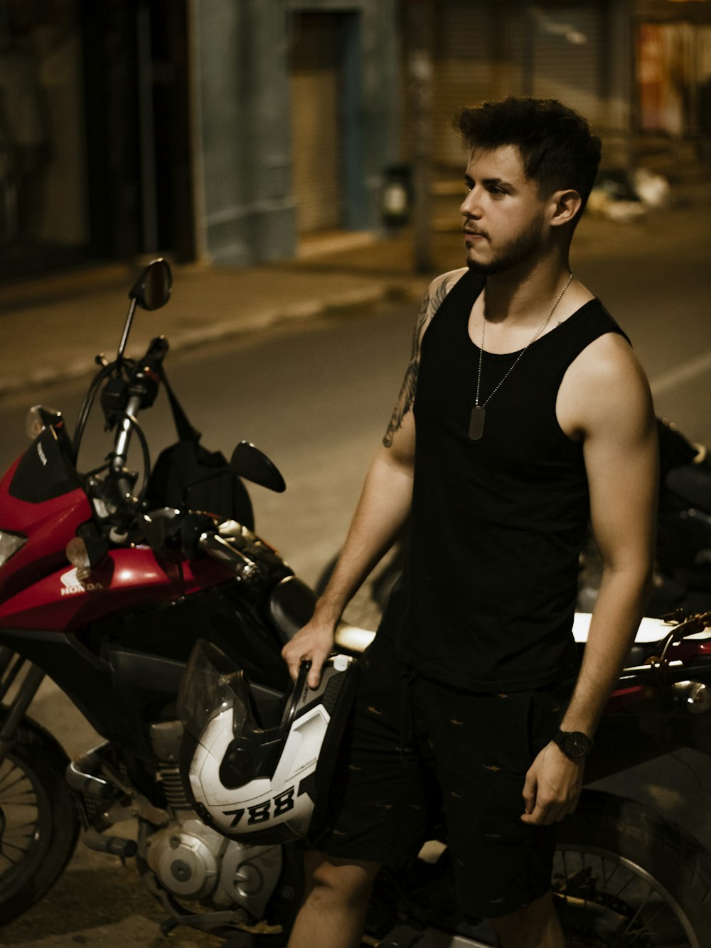 a man standing next to a parked motorcycle