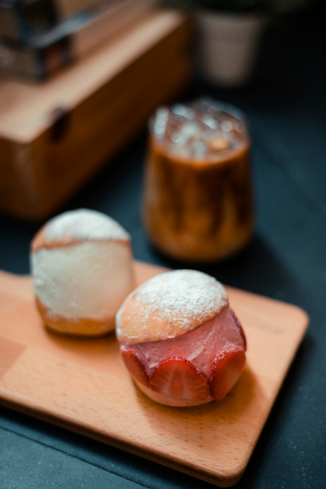 a wooden cutting board topped with pastries covered in powdered sugar