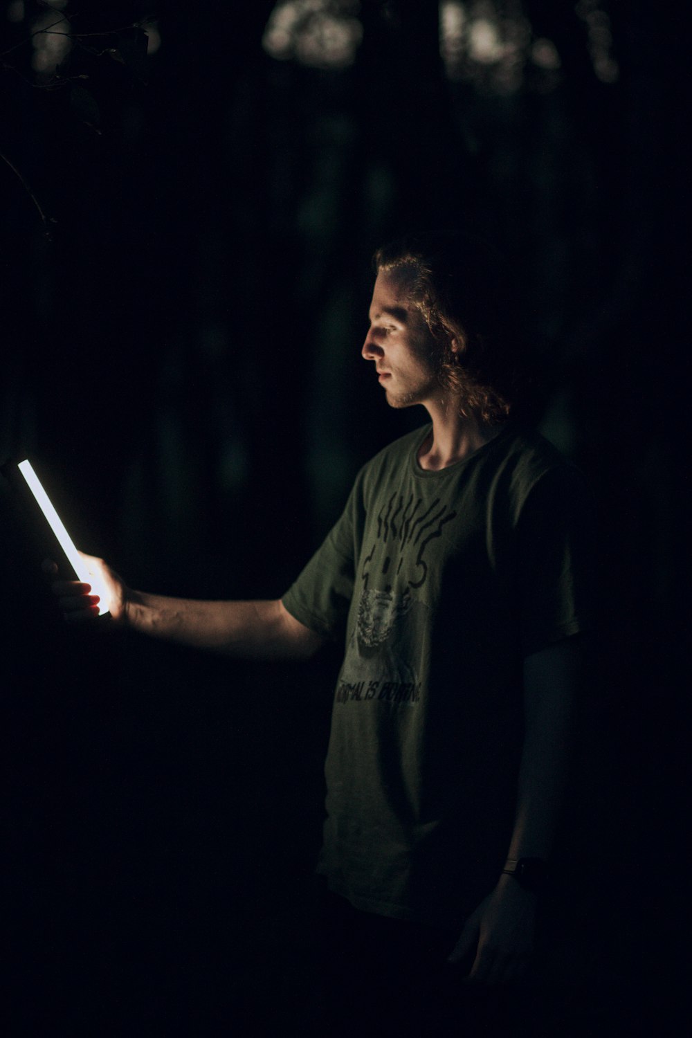 a man holding a light in the dark