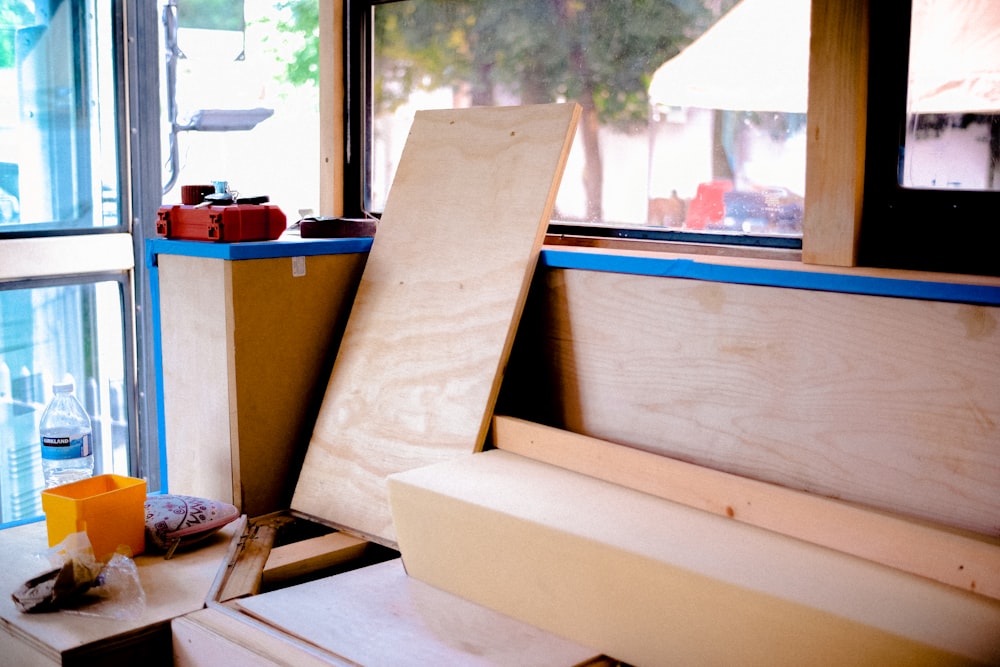 a wooden bench sitting in front of a window