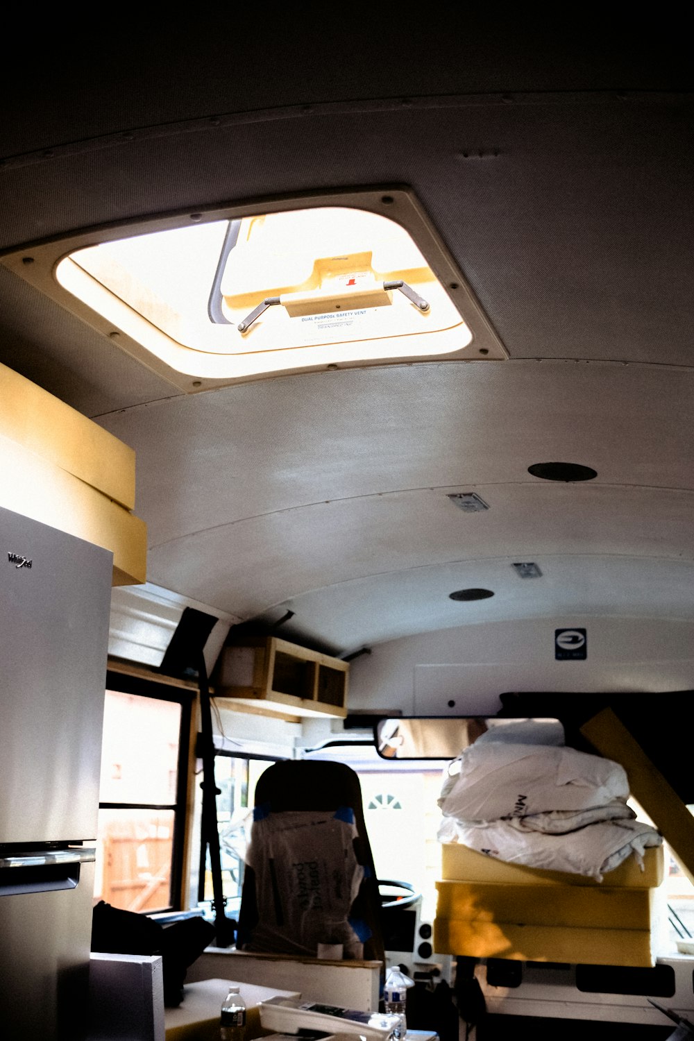 the inside of a bus with a table and refrigerator