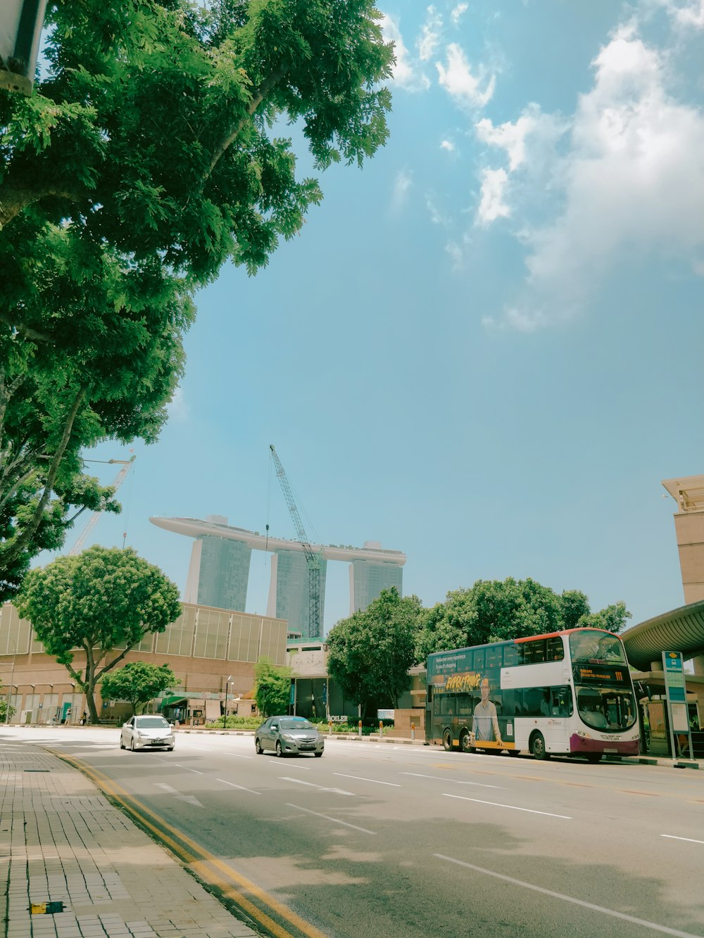 a city street with cars and a double decker bus