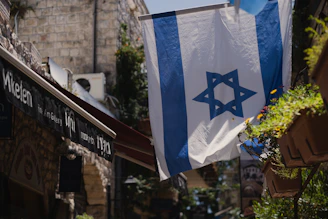 a flag hanging from a building in a city