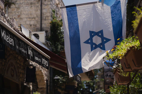 a flag hanging from a building in a city