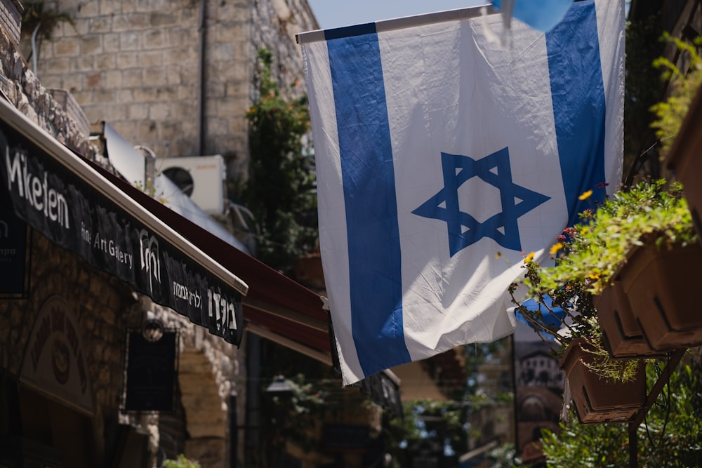 a flag hanging from a building in a city