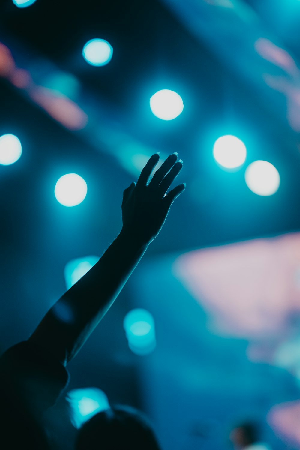 a person raising their hand up in front of a crowd