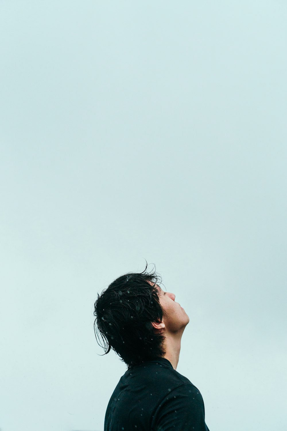 a man looking up at a kite in the sky