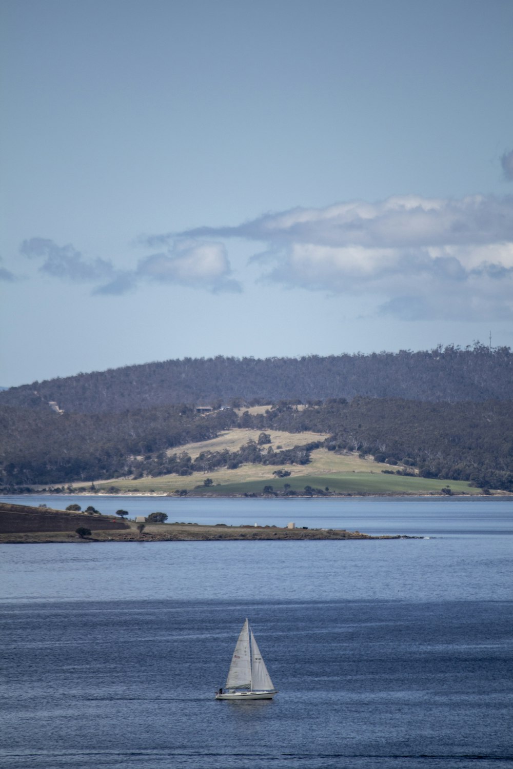 a small sailboat in a large body of water