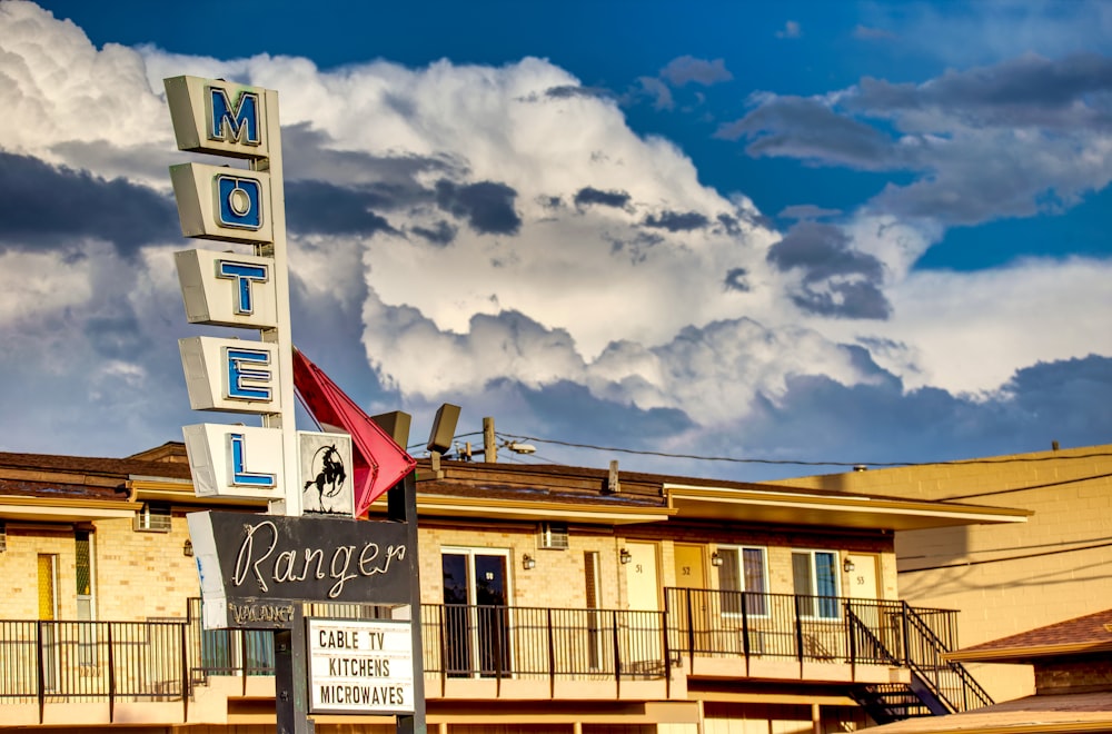 a motel sign in front of a cloudy sky
