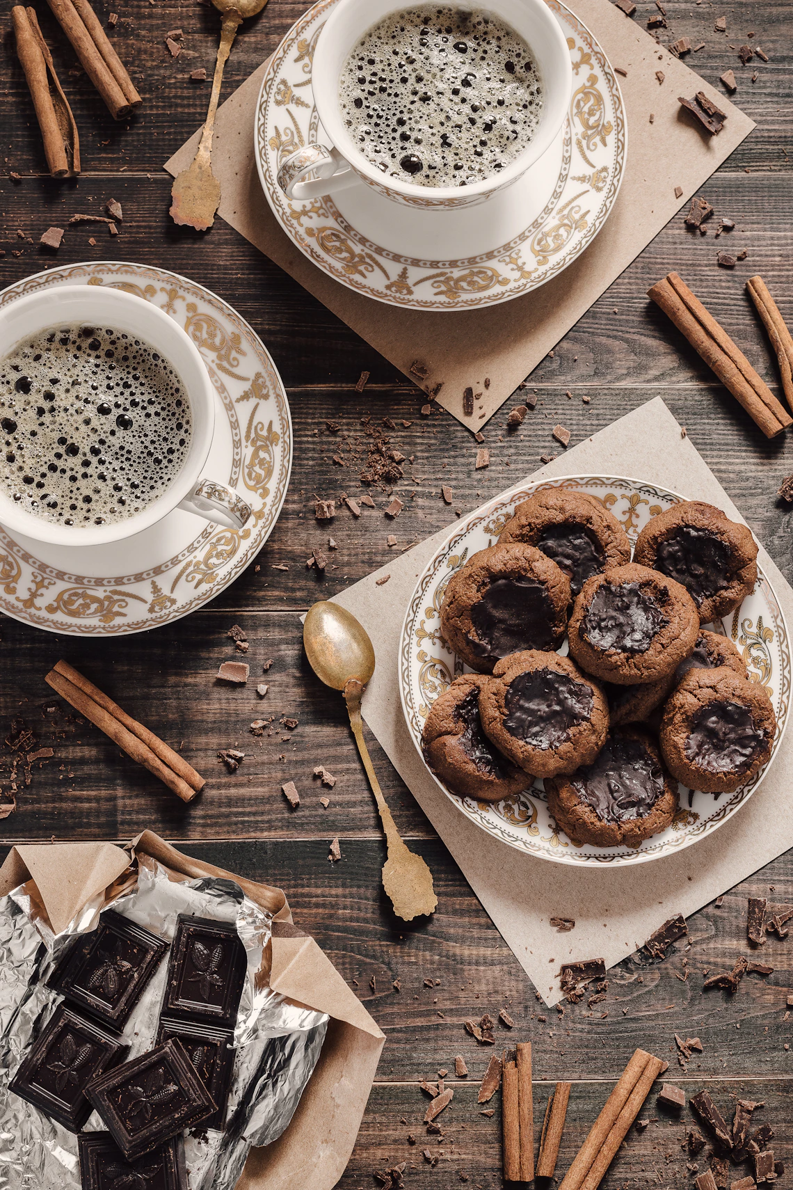 Chocolate cookies and cups of coffee arranged on a table.