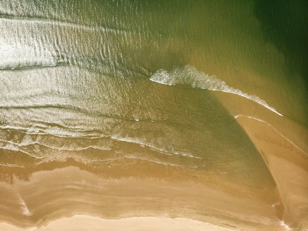 an aerial view of a sandy beach and ocean