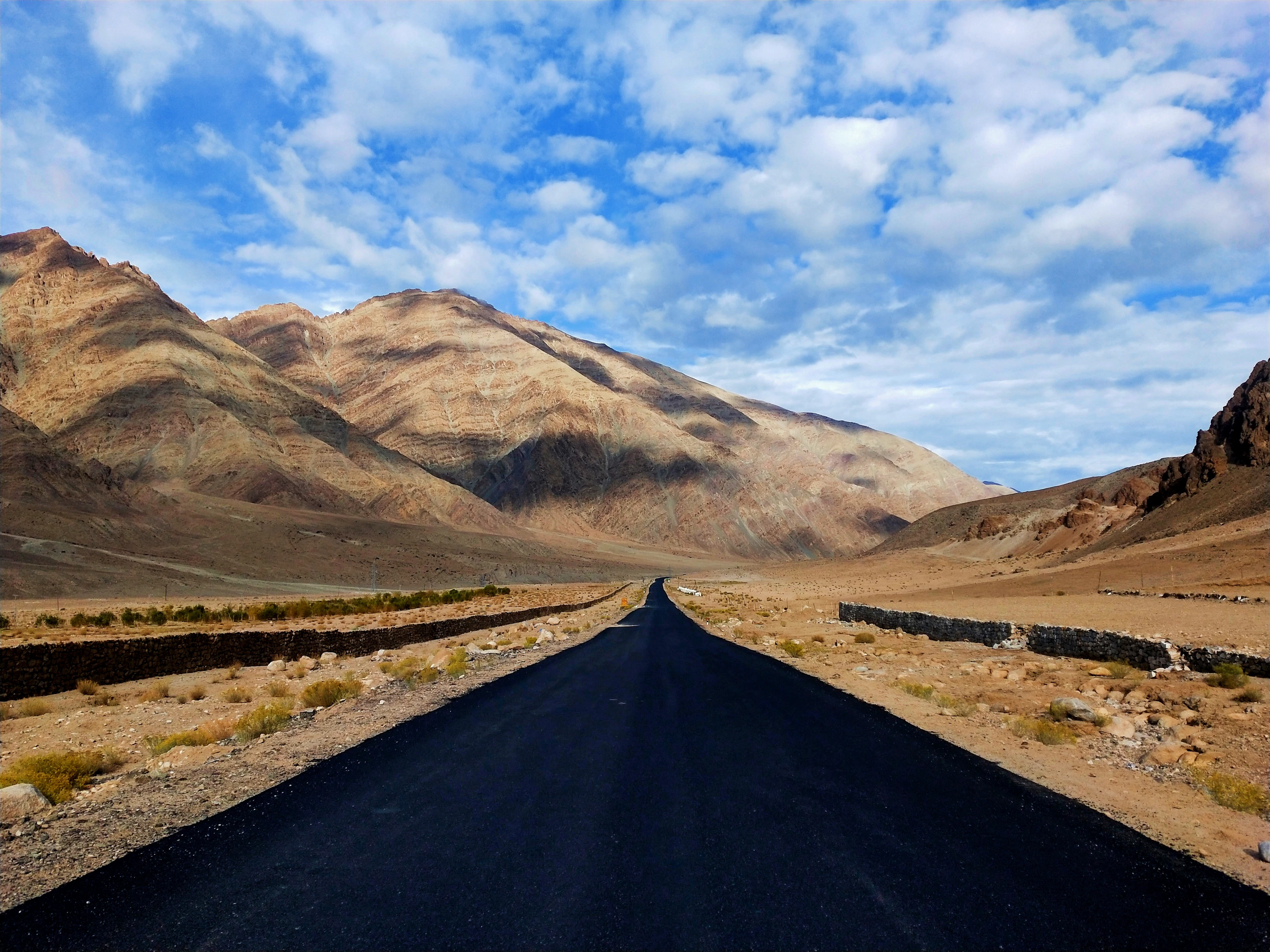 A long empty road crossing the cold desert of Ladakh
