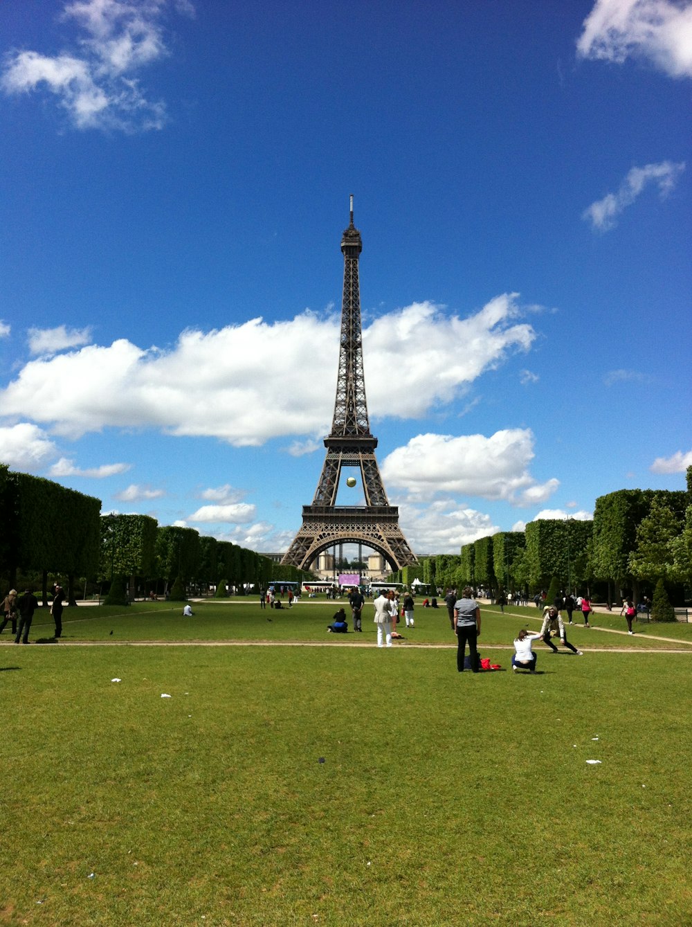 a group of people standing in front of the eiffel tower