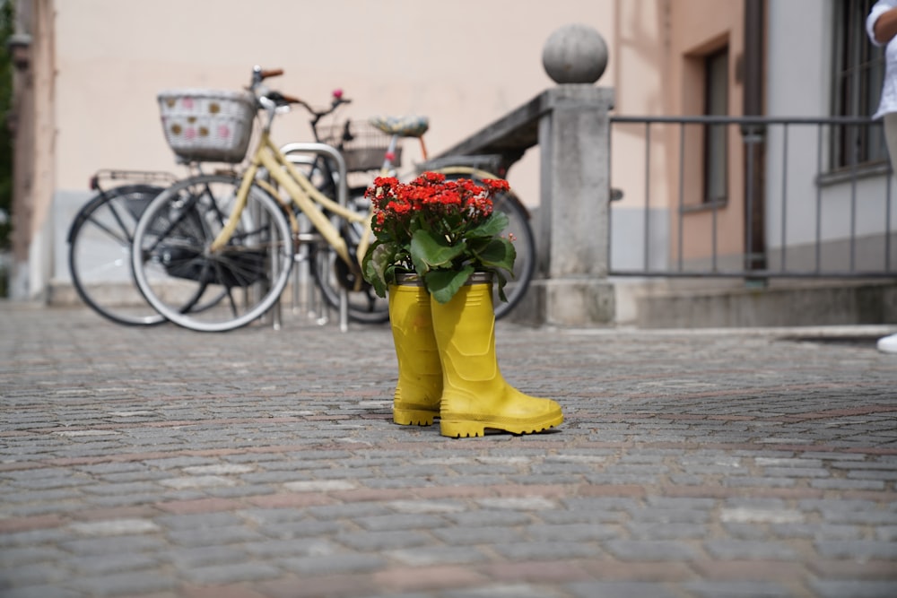 a pair of yellow rain boots with flowers in them