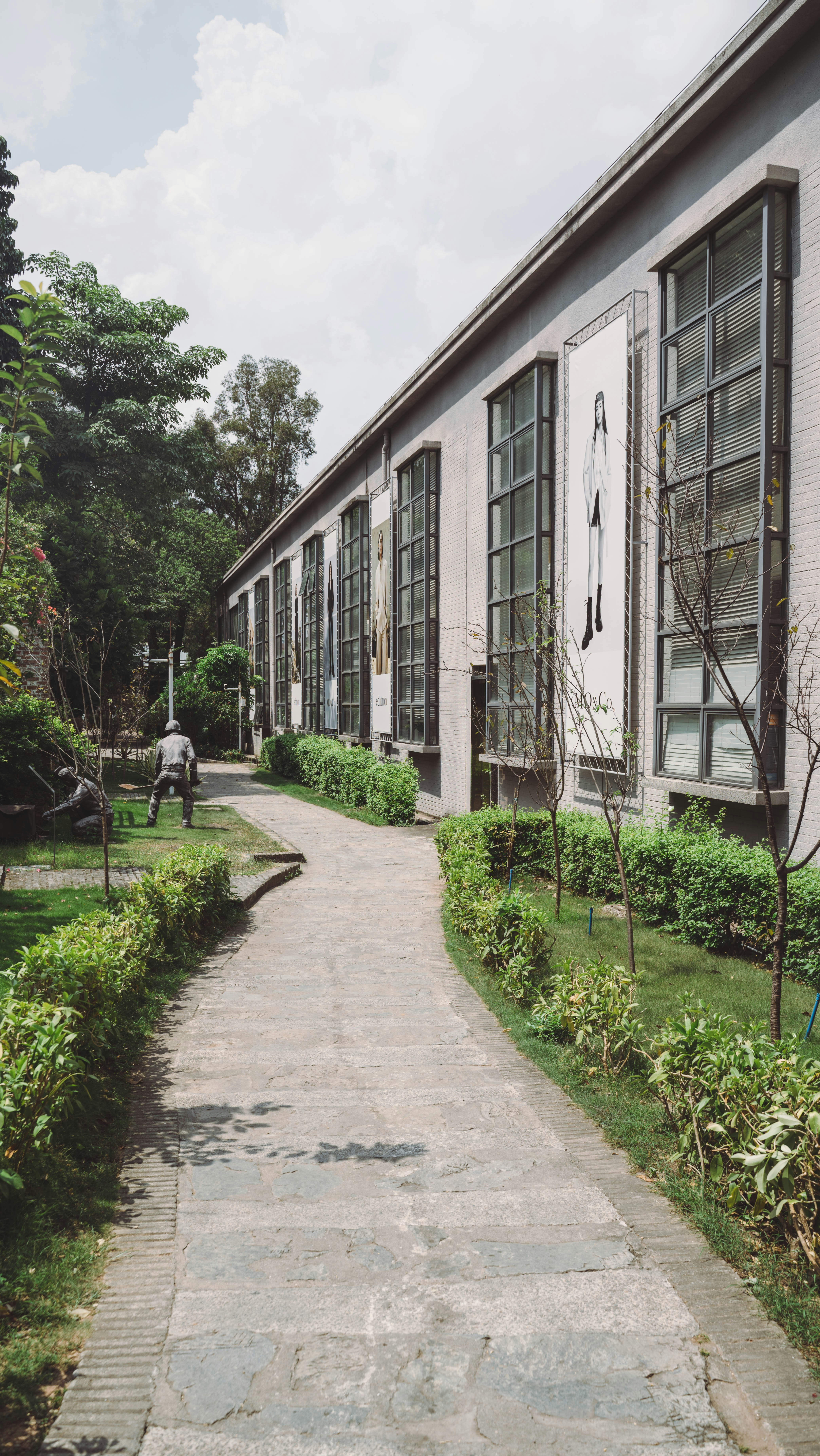 a walkway leading to a building with a clock on the side of it