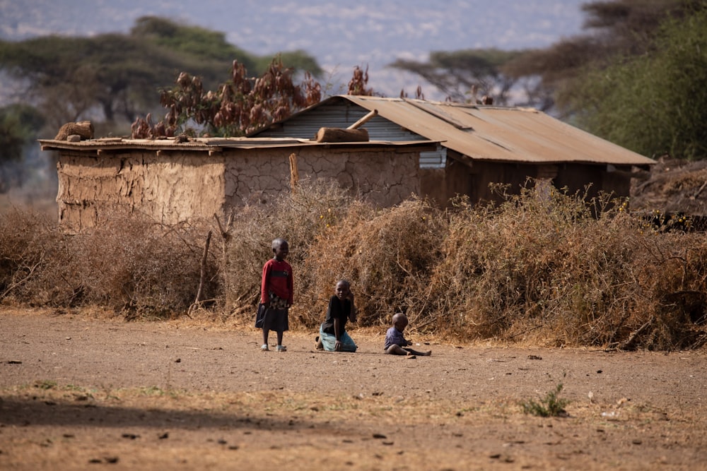 a group of people standing around a dirt field