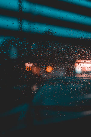 a view of a street through a rain covered window