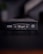 A close-up view of a black box of premium playing cards with the brand names Marvel and Theory11 prominently displayed. The design includes sleek typography and logo symbols, conveying a sense of luxury and exclusivity. The box is situated on a dark surface with a blurred background.