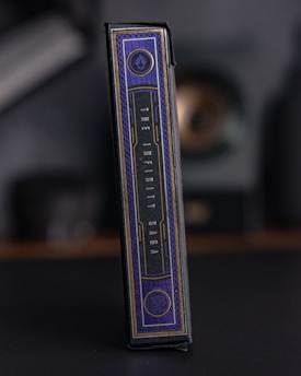 A rectangular box with elegant design elements, featuring a dark color palette with gold accents. The text 'The Infinity Saga' is prominently displayed on the side. The setting appears dark and muted, emphasizing the luxurious feel of the packaging.