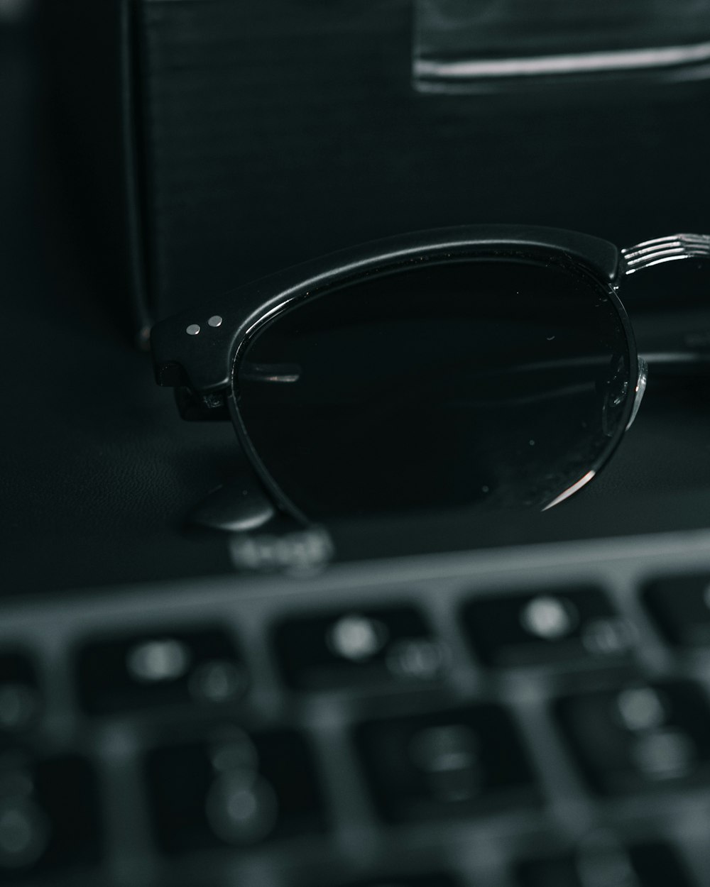 a pair of glasses sitting on top of a keyboard