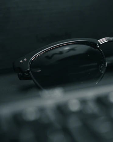 Stylish round-frame sunglasses with dark lenses, placed against a minimalist background.