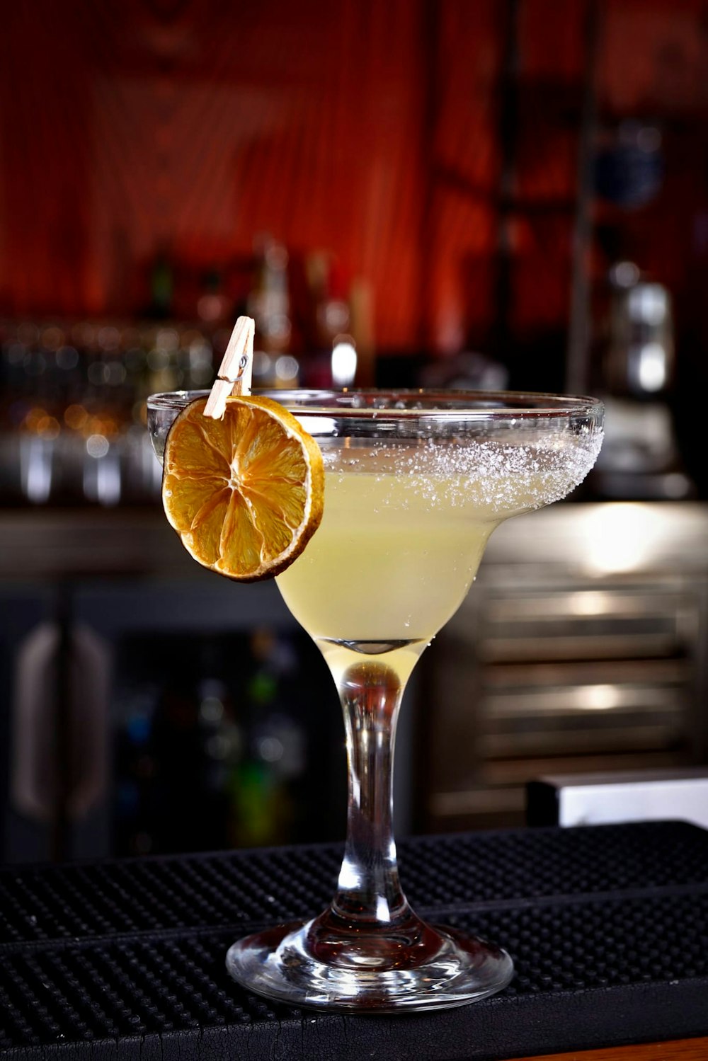 a glass filled with a drink sitting on top of a counter