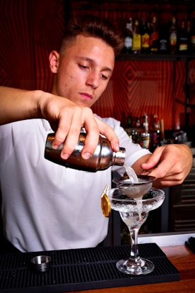 a man pouring a drink into a glass