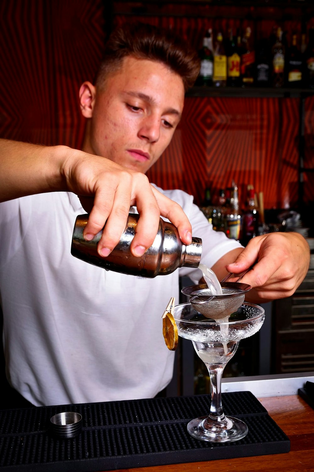 a man pouring a drink into a glass