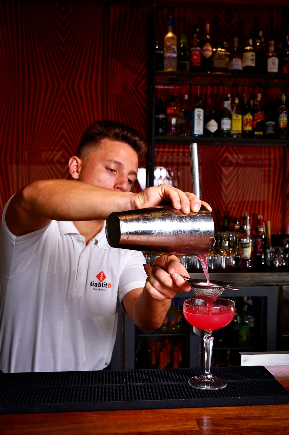 um homem fazendo uma bebida em um bar