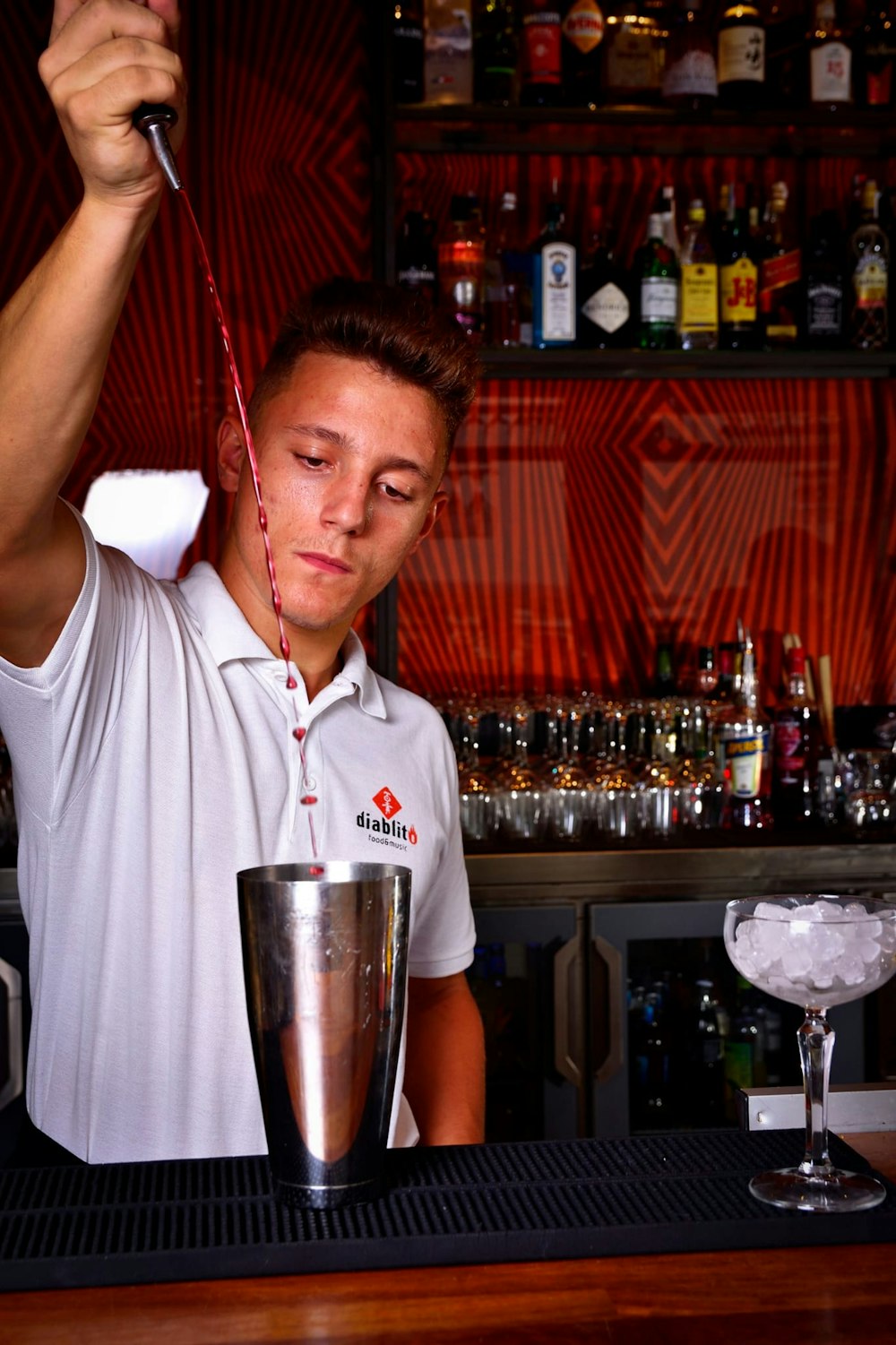 a man in a white shirt is behind a bar