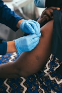 a person in blue gloves is getting a vaccium