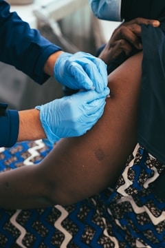 a person in blue gloves is getting a vaccium