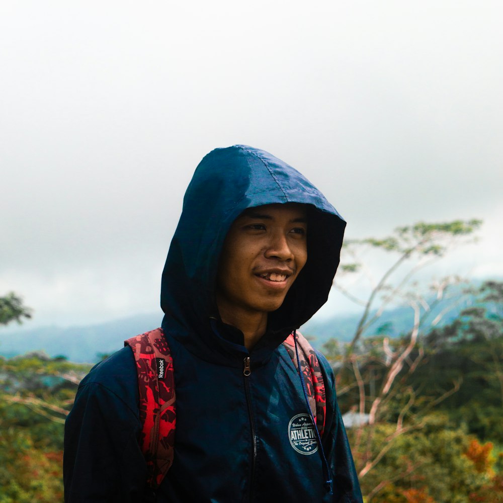 a man with a blue jacket and a red backpack