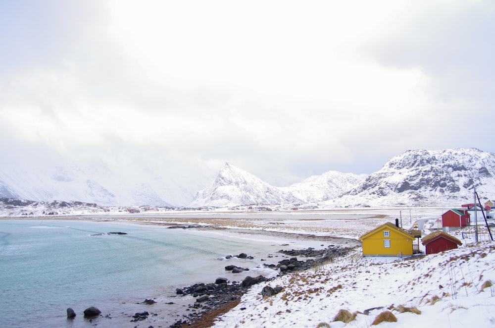 a small yellow house on the shore of a body of water