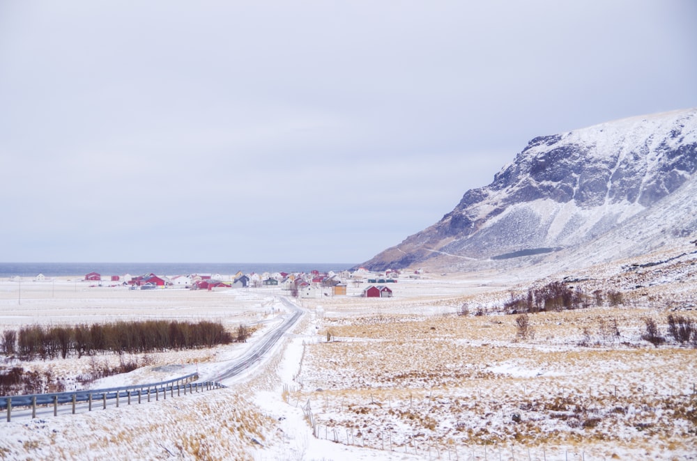 uma longa estrada no meio de um campo nevado