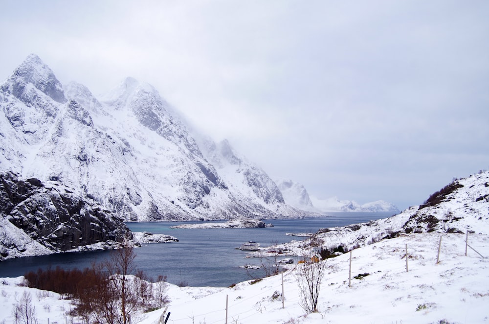 a snow covered mountain with a body of water in the foreground