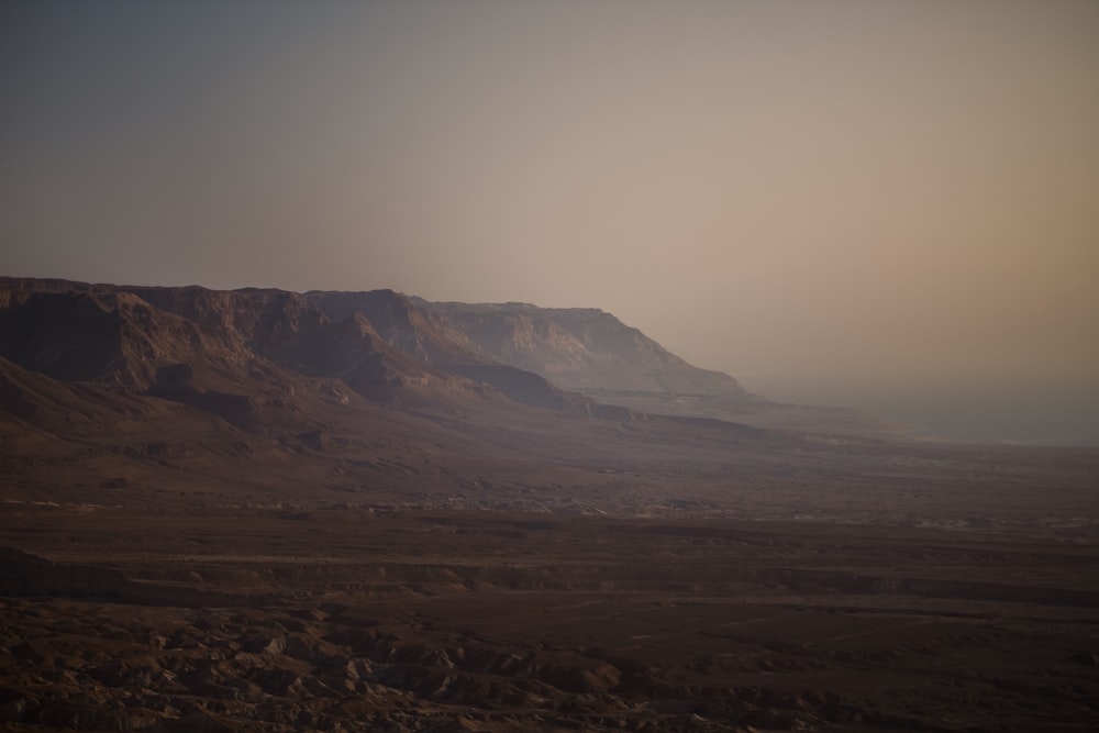 Un paisaje desértico con una montaña en la distancia