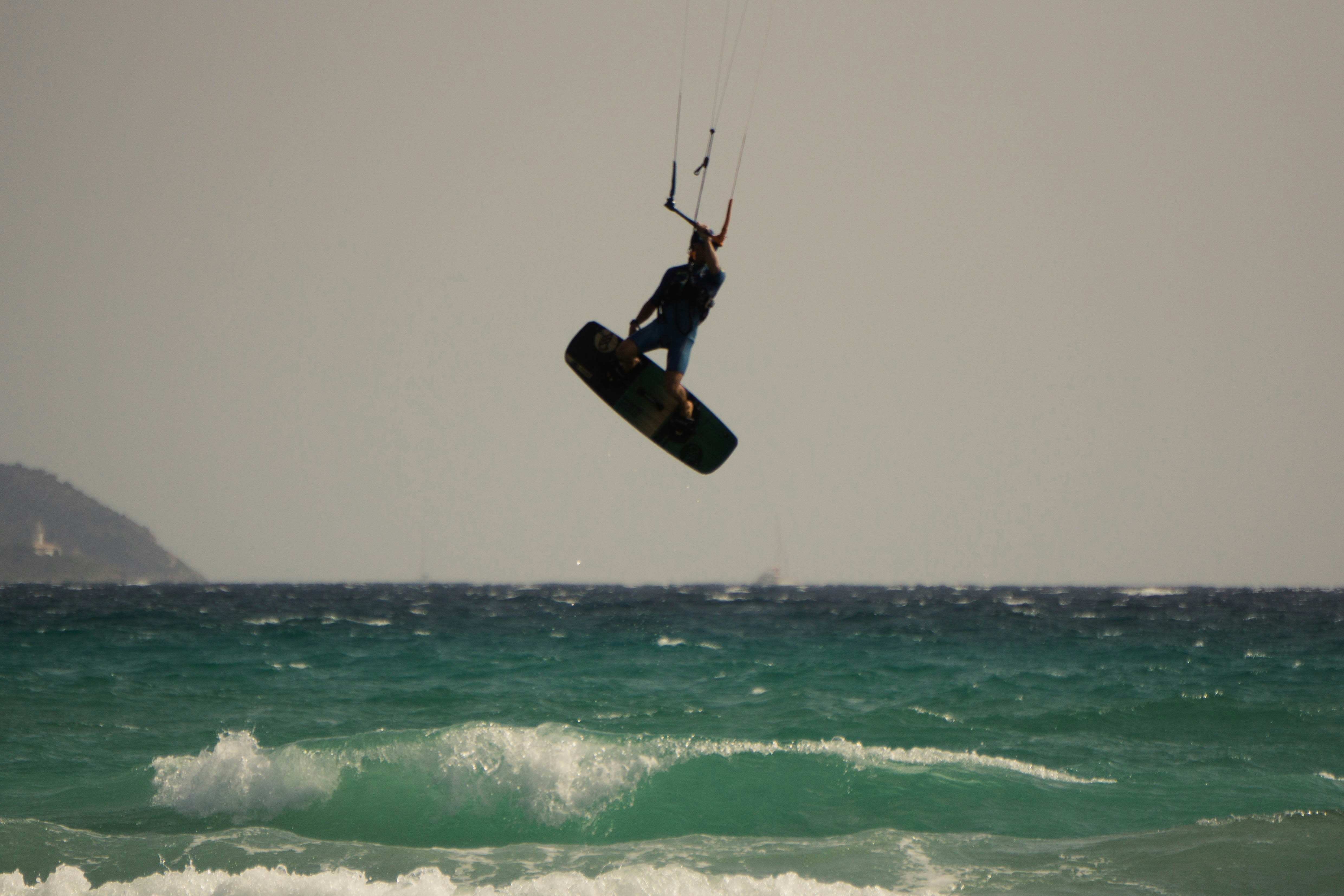 a person on a surfboard in the air over the ocean
