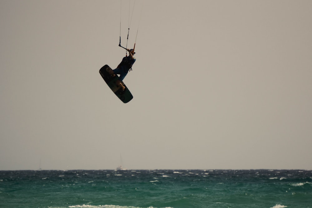 a parasailer is in the air over the ocean