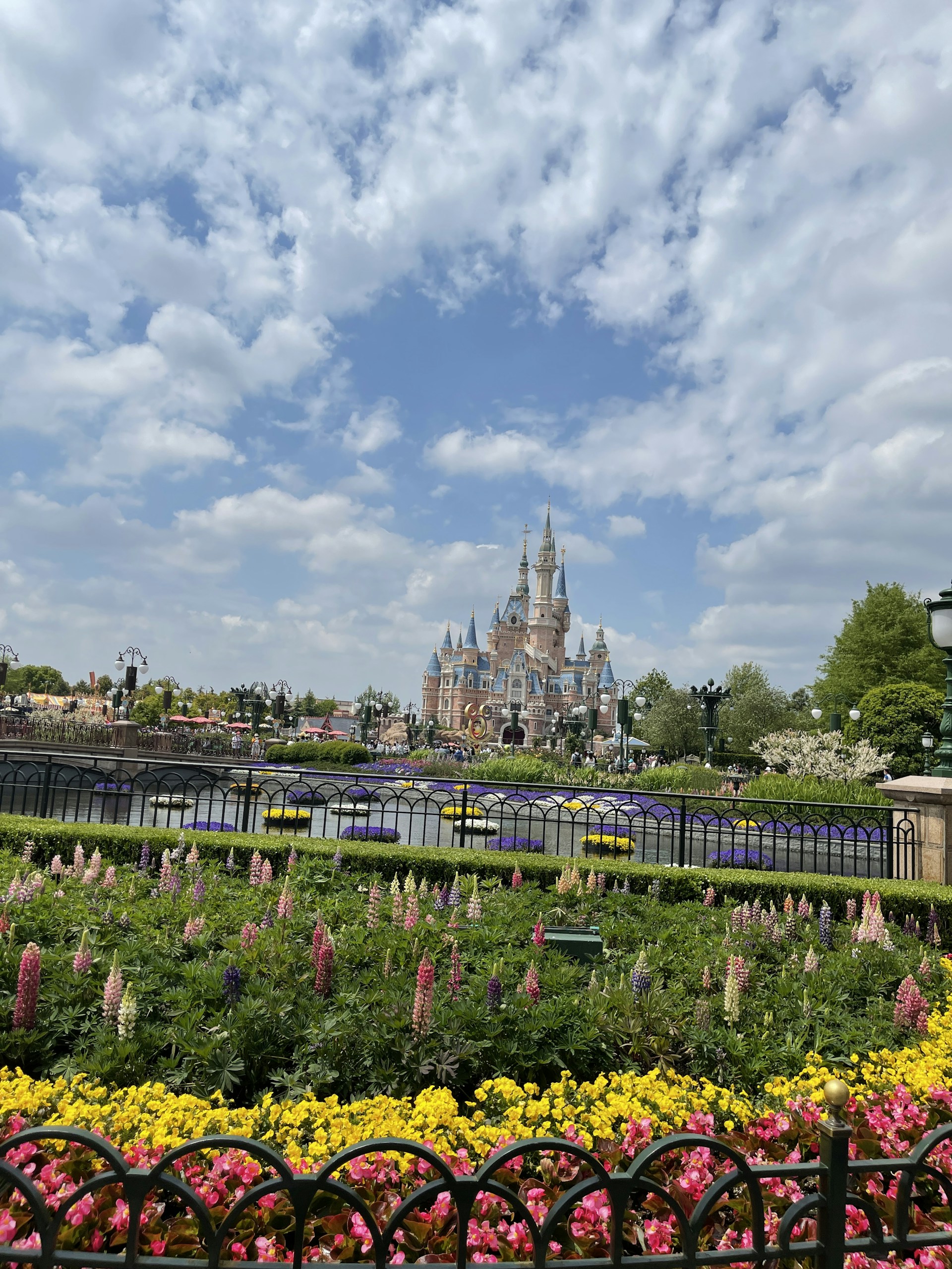 A serene garden with blooming pastel flowers and a majestic castle in the background, bathed in golden sunlight.