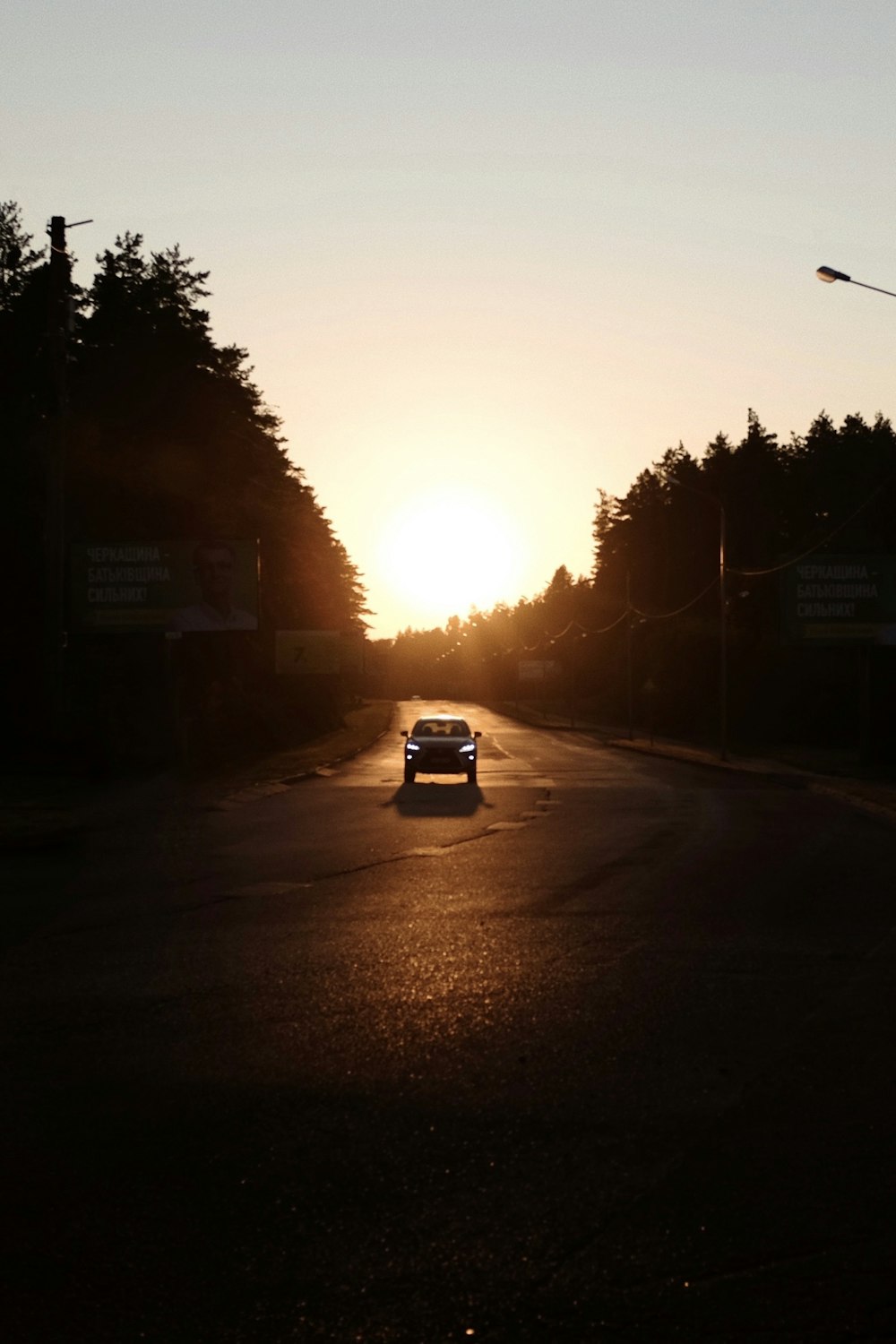 a car driving down a street at sunset